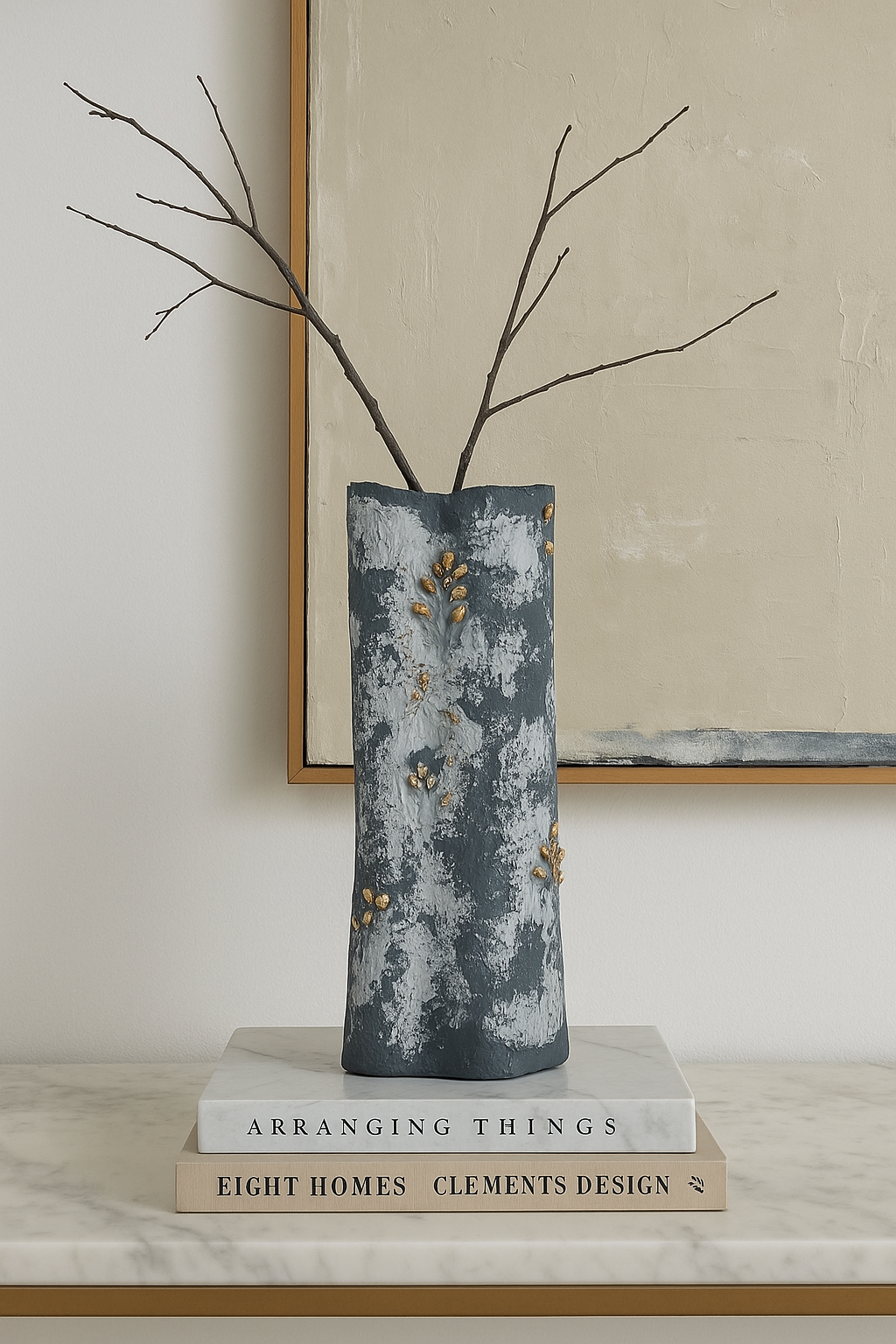 Textured handmade blue vase styled with dry branches, sitting on designer books in a minimal decor setup.