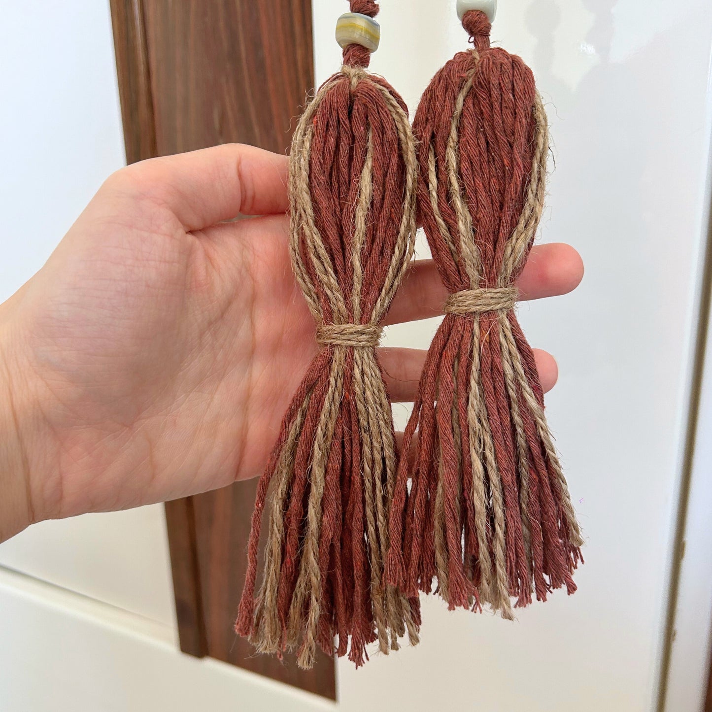 Close-up of jute tassels and earthy glass beads on rustic handmade garland