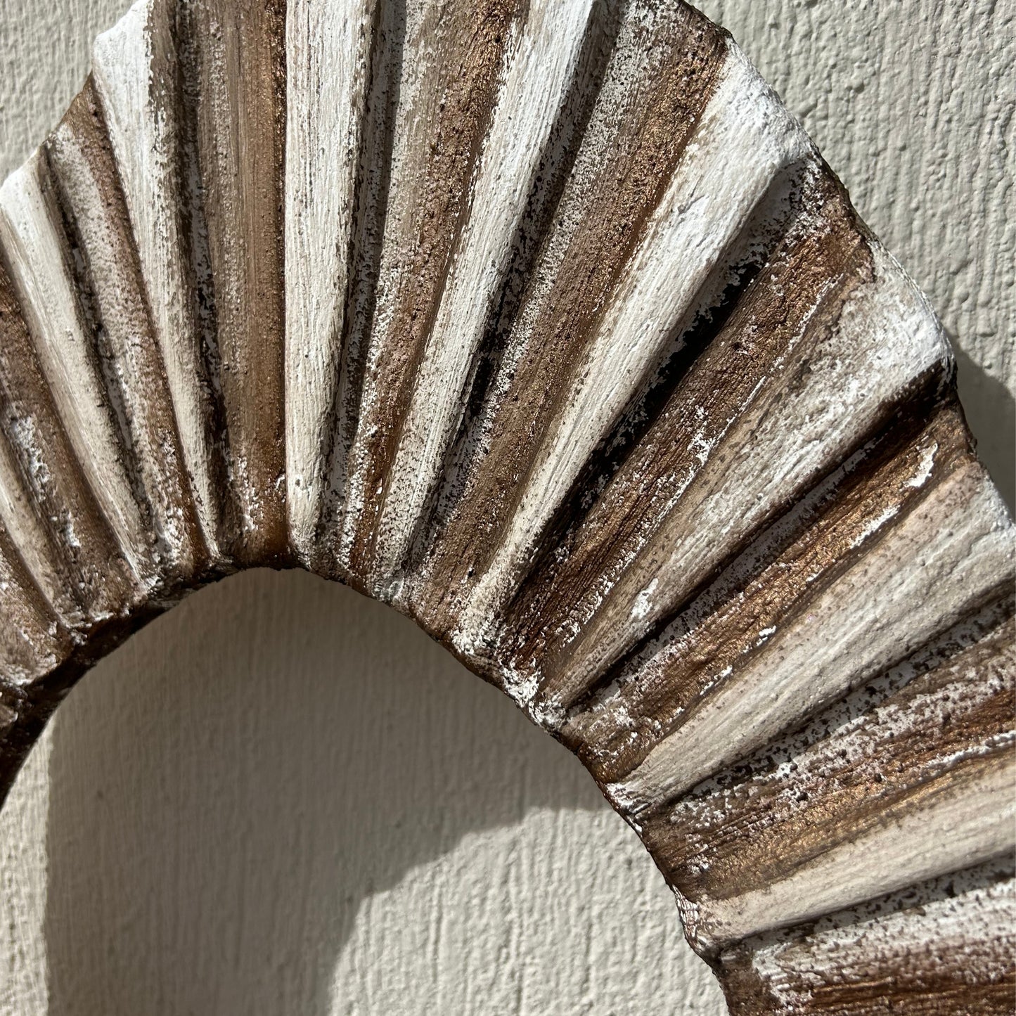 Close-up detail of ridged wall art texture in neutral bronze tones