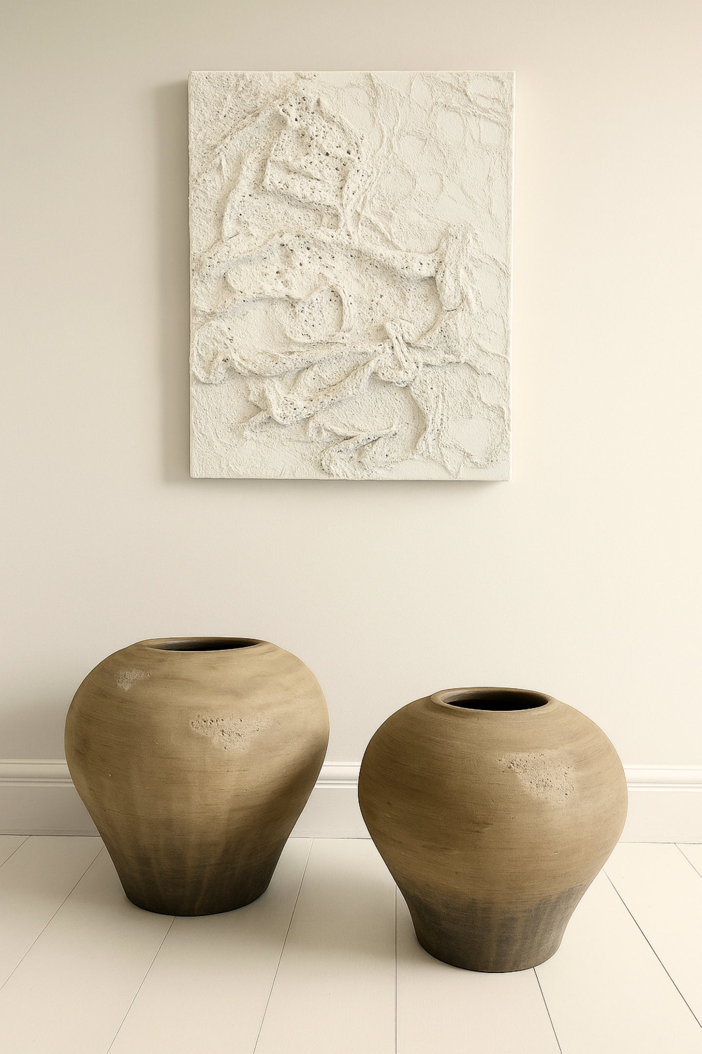 Handmade white textured canvas wall art inspired by ocean coral patterns, styled above two large organic clay vases in a minimal Japandi interior
