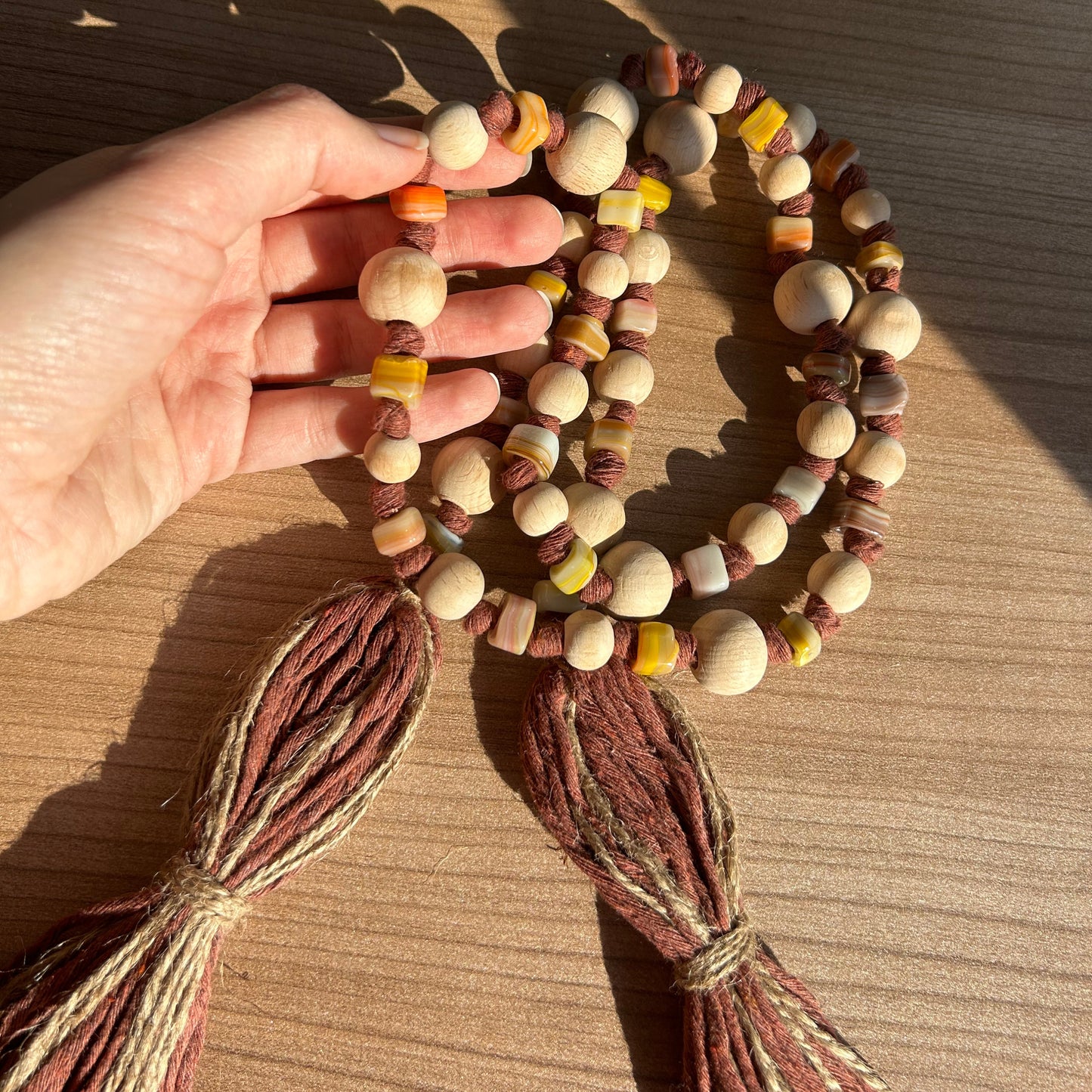 Earth-toned wooden beads on handmade rustic curtain tieback