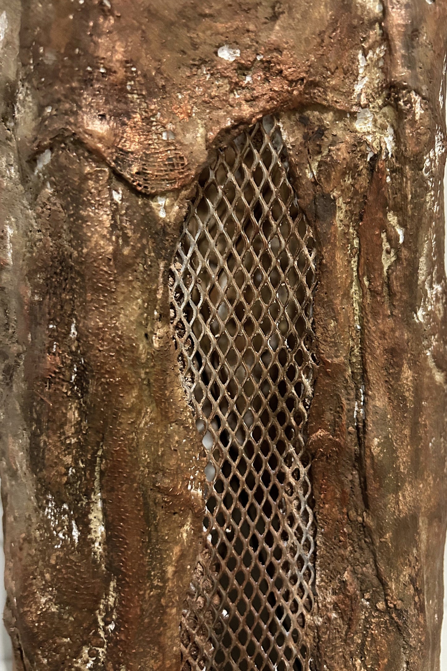 Close-up of handmade textured floor vase with natural aged bronze tones