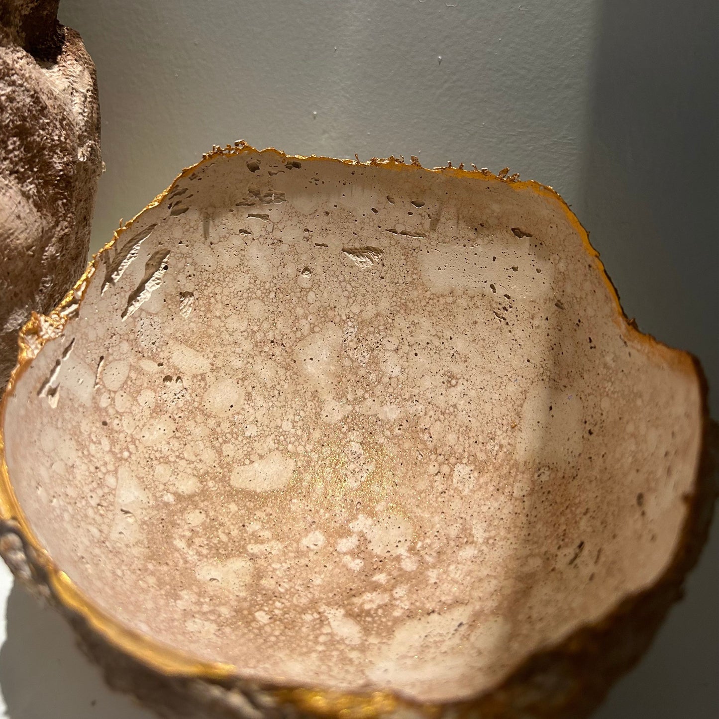 Interior of the handmade bowl showing soft light reflections and organic plaster texture.