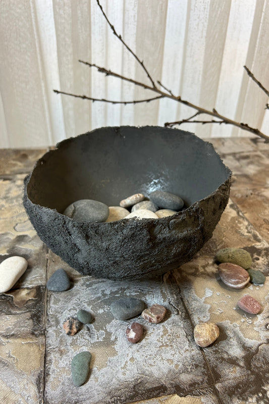 Eco-friendly wabi sabi bowl styled with natural pebbles and dried branches.
