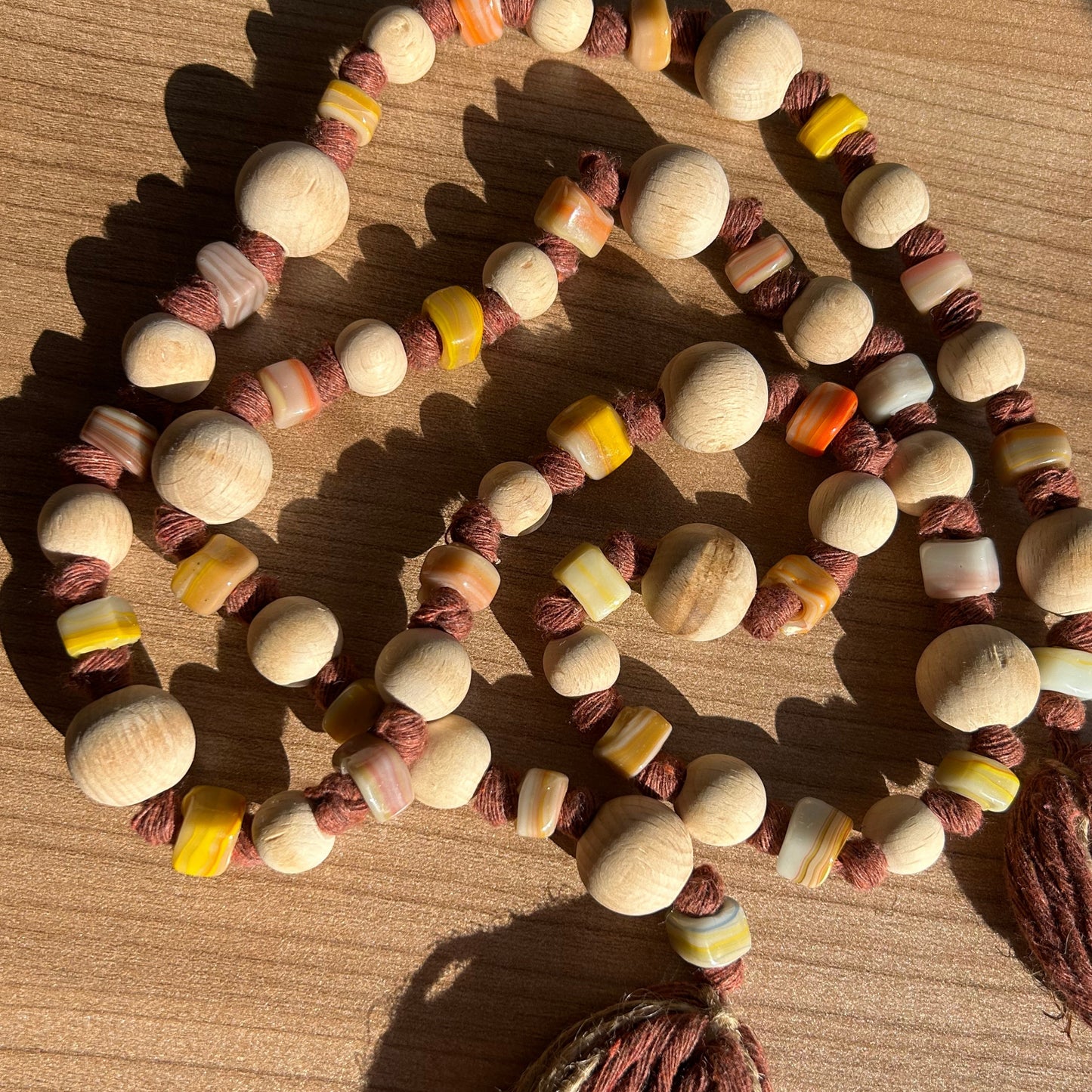 Detailed view of wooden and glass beads in warm tones on handmade garland