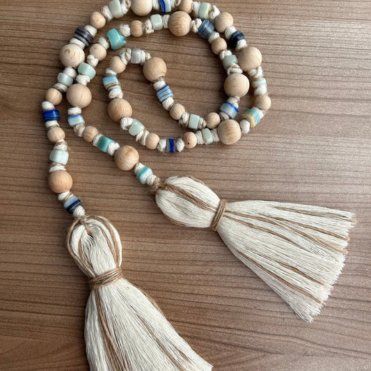 Rustic handmade garland laid out flat with visible knotting and tassel detail.