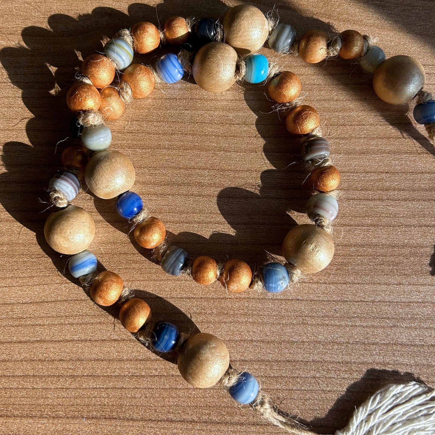 Beaded garland sparkling under sunlight, showing natural wood and glass bead details