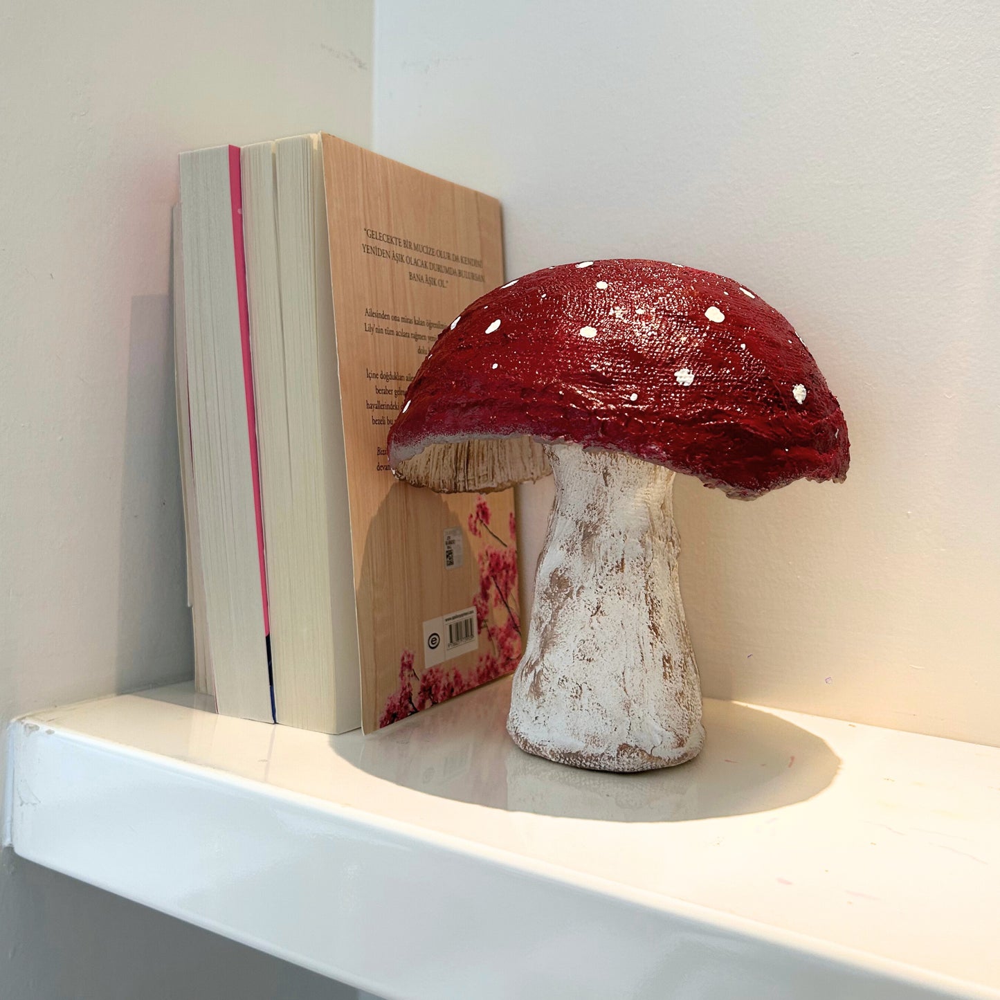 Paper mache mushroom sculpture styled with books and minimalist decor