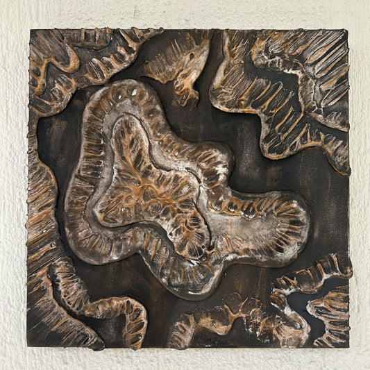 Front-facing square wall art with bronze highlights and black clay base