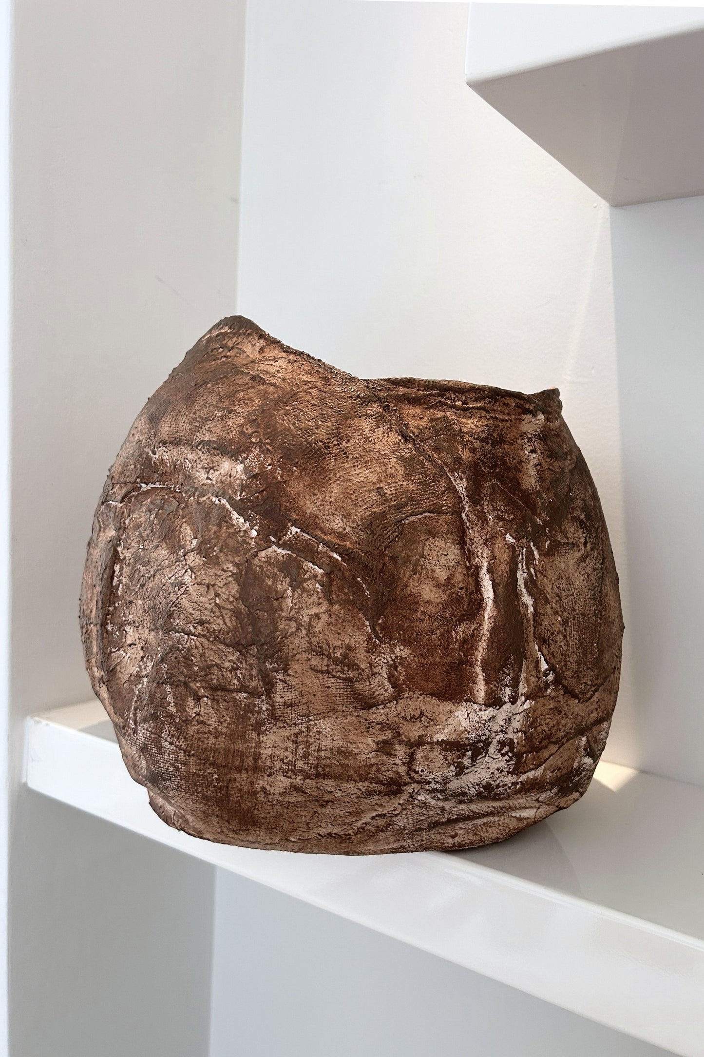 Front view of a handmade wabi sabi vase with textured earthy surface and organic shape, placed on a white background.