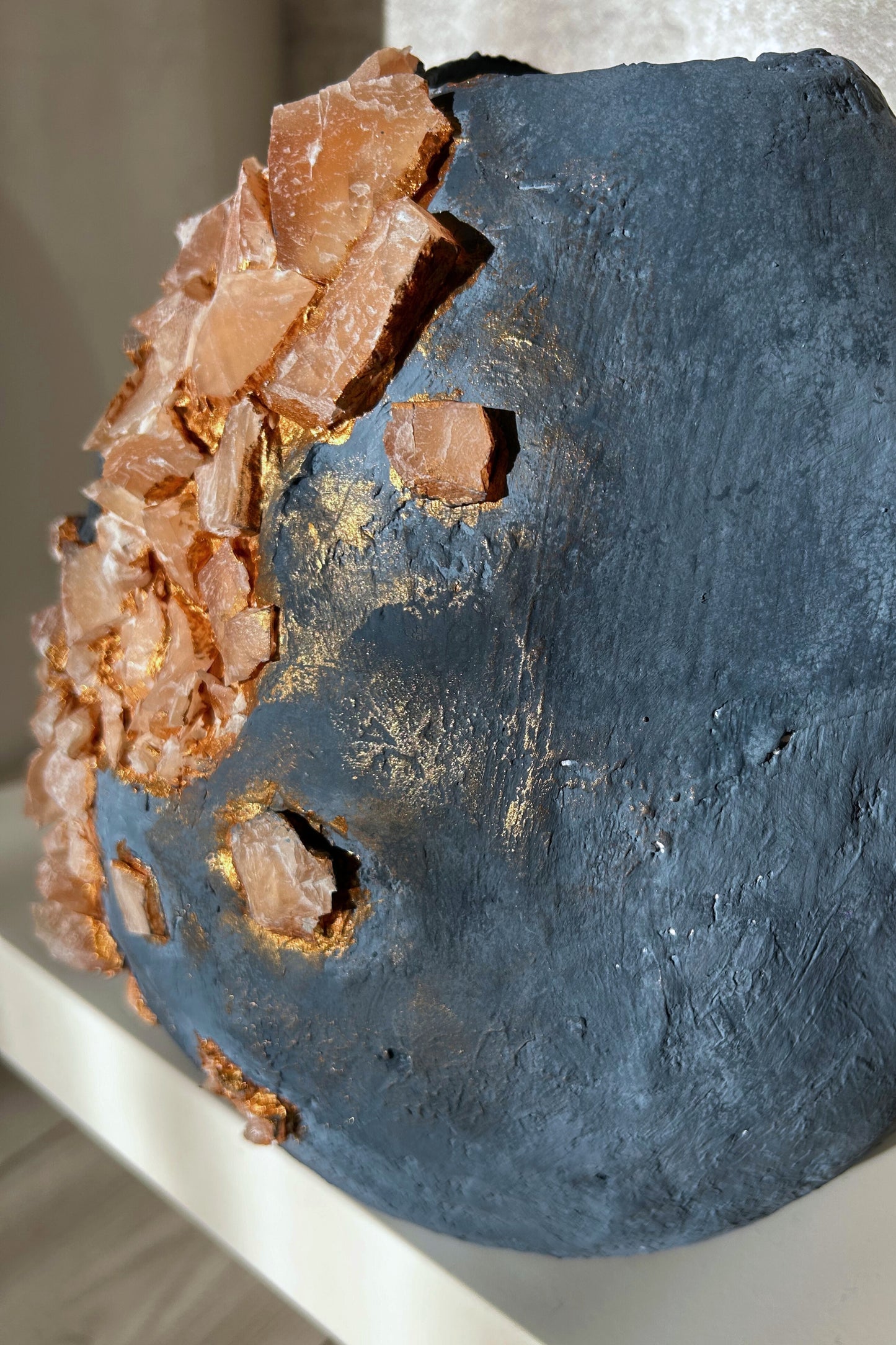 Macro close-up of natural marble pieces on textured blue vase surface