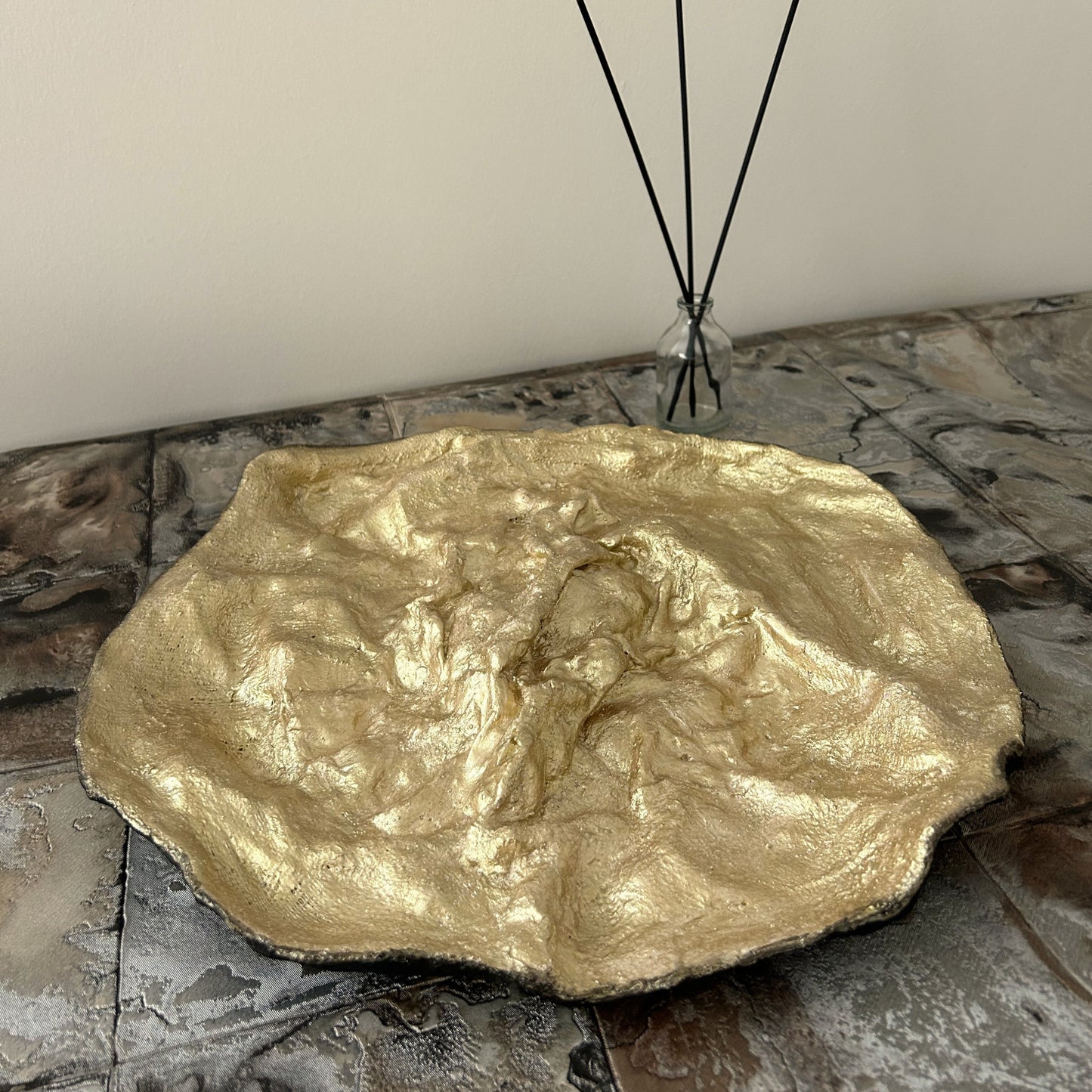 Modern rustic tray with black outer texture and radiant gold interior