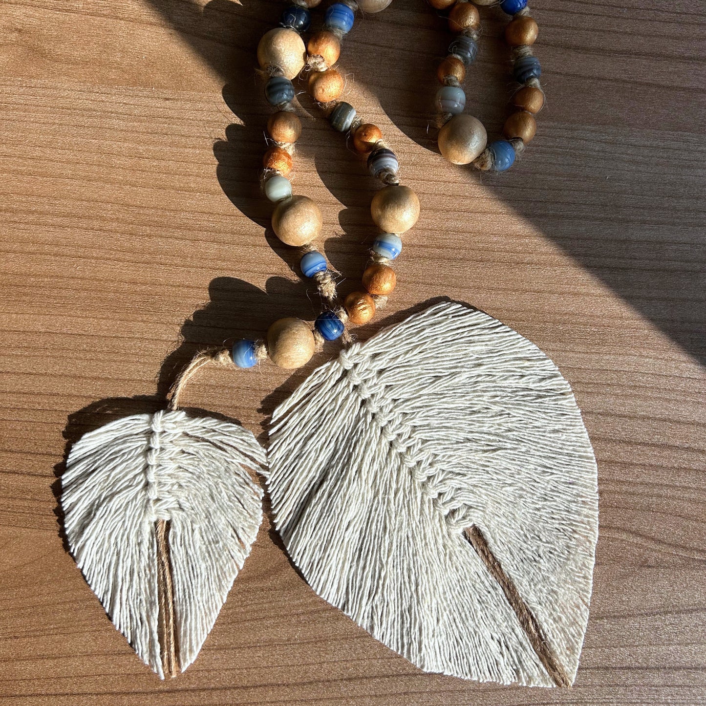 Focus on handcrafted jute leaves and earth-toned beadwork, captured in warm light