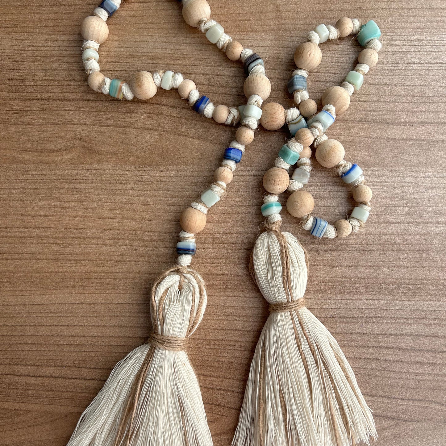 Detailed shot of macrame tassel curtain tieback featuring wooden and glass beads.