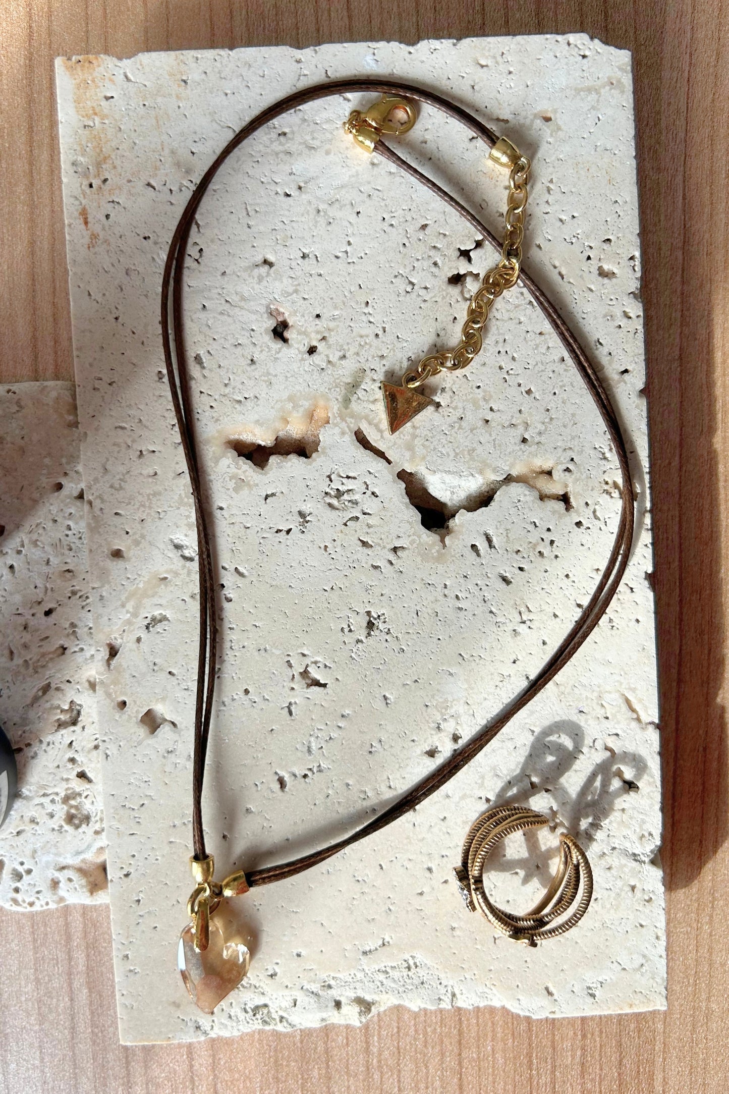 Beige travertine tray styled with necklace and earrings for aesthetic presentation