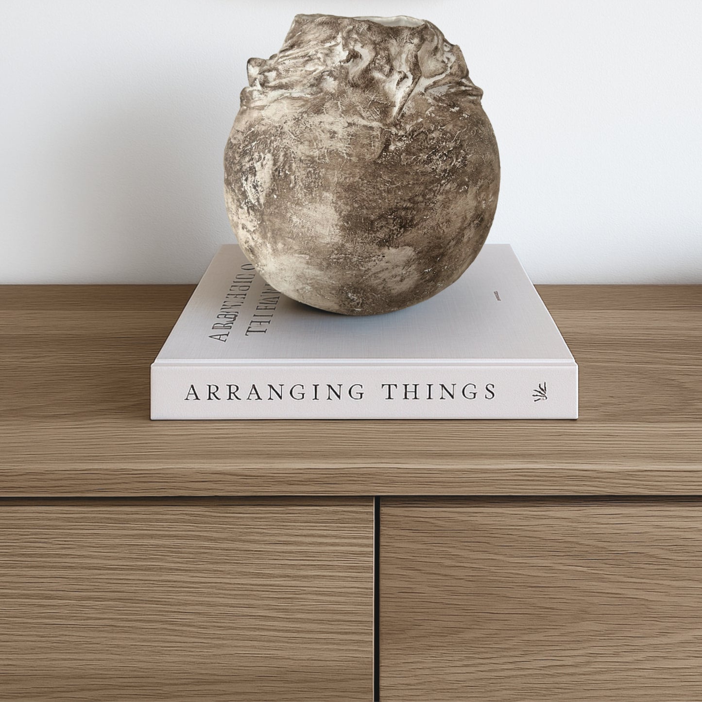Rustic wabi-sabi style sculptural vase displayed on a coffee table book stack, adding natural charm to a minimal Scandinavian-inspired interior.
