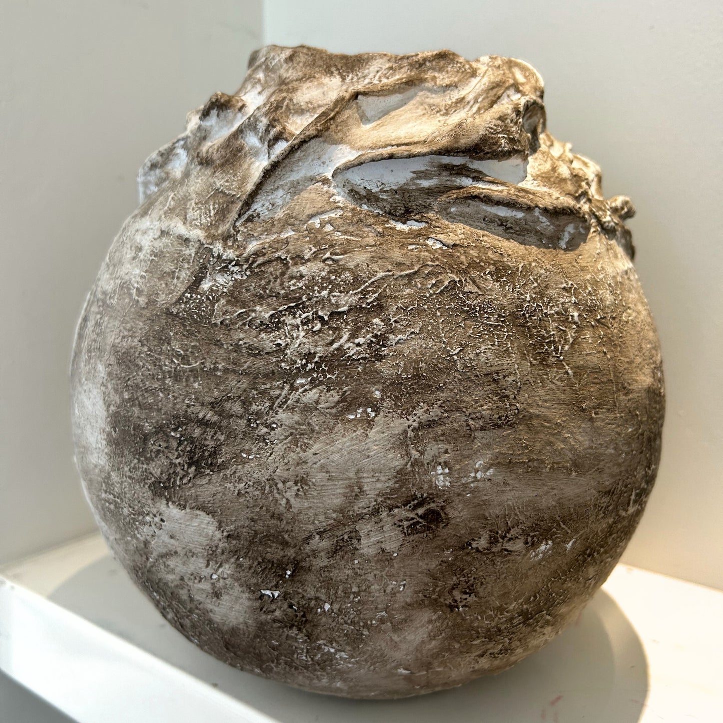 Close-up of sculpted wabi-sabi vase showing natural earthy texture and organic curves.