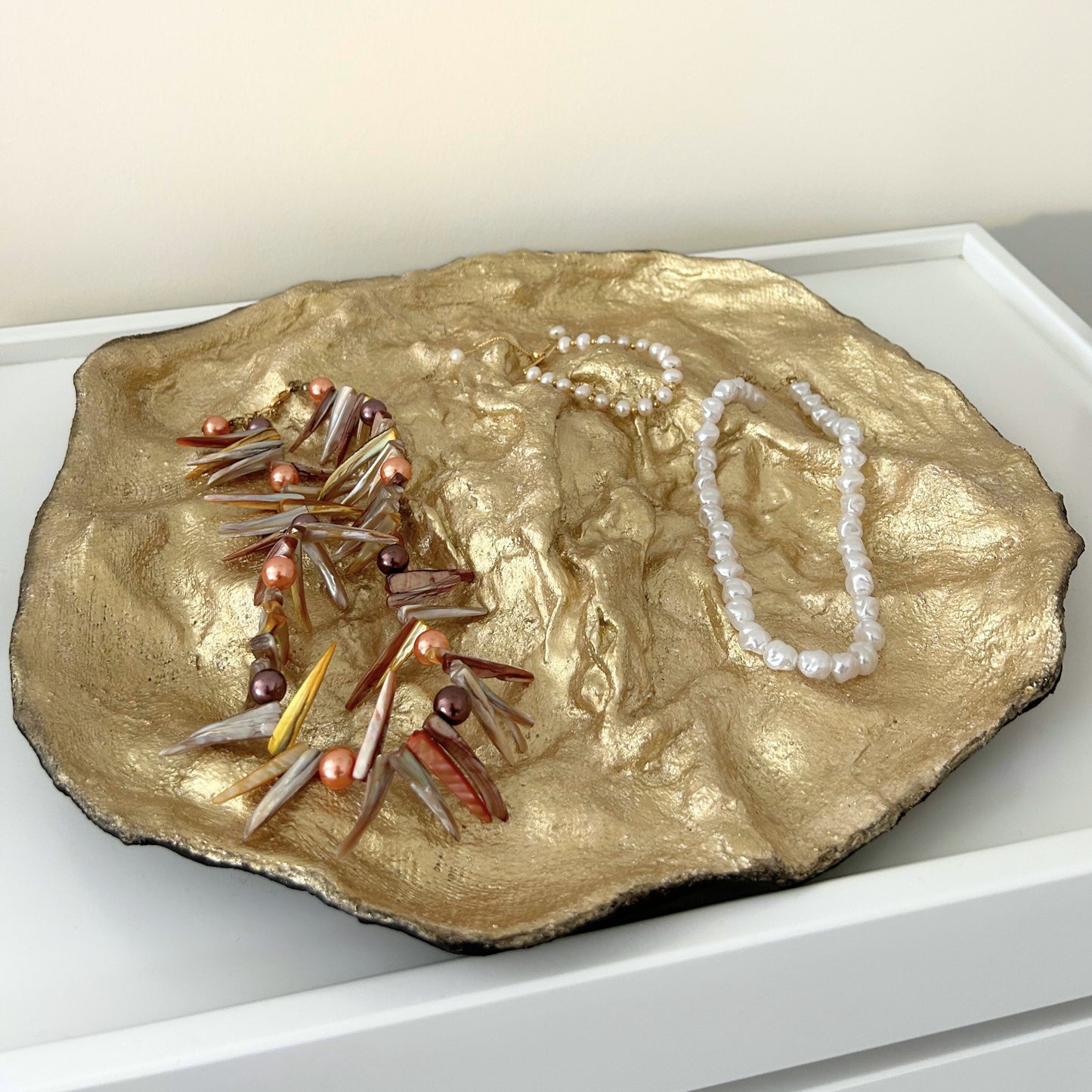 Handmade gold paper mache tray displayed with jewelry for summer styling