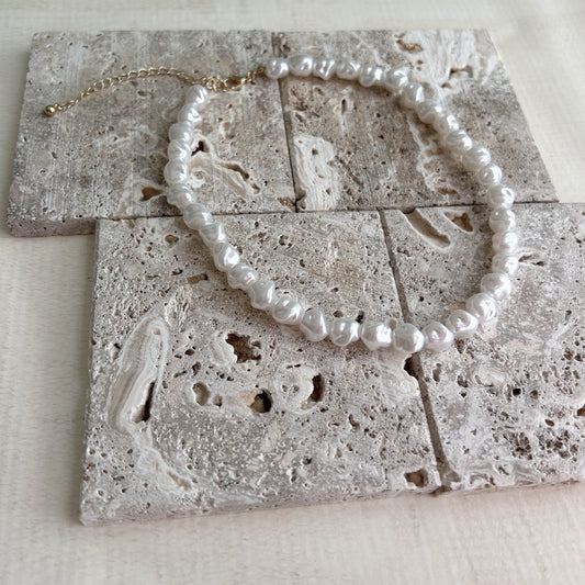 Circular jewelry pieces placed on natural textured stone blocks