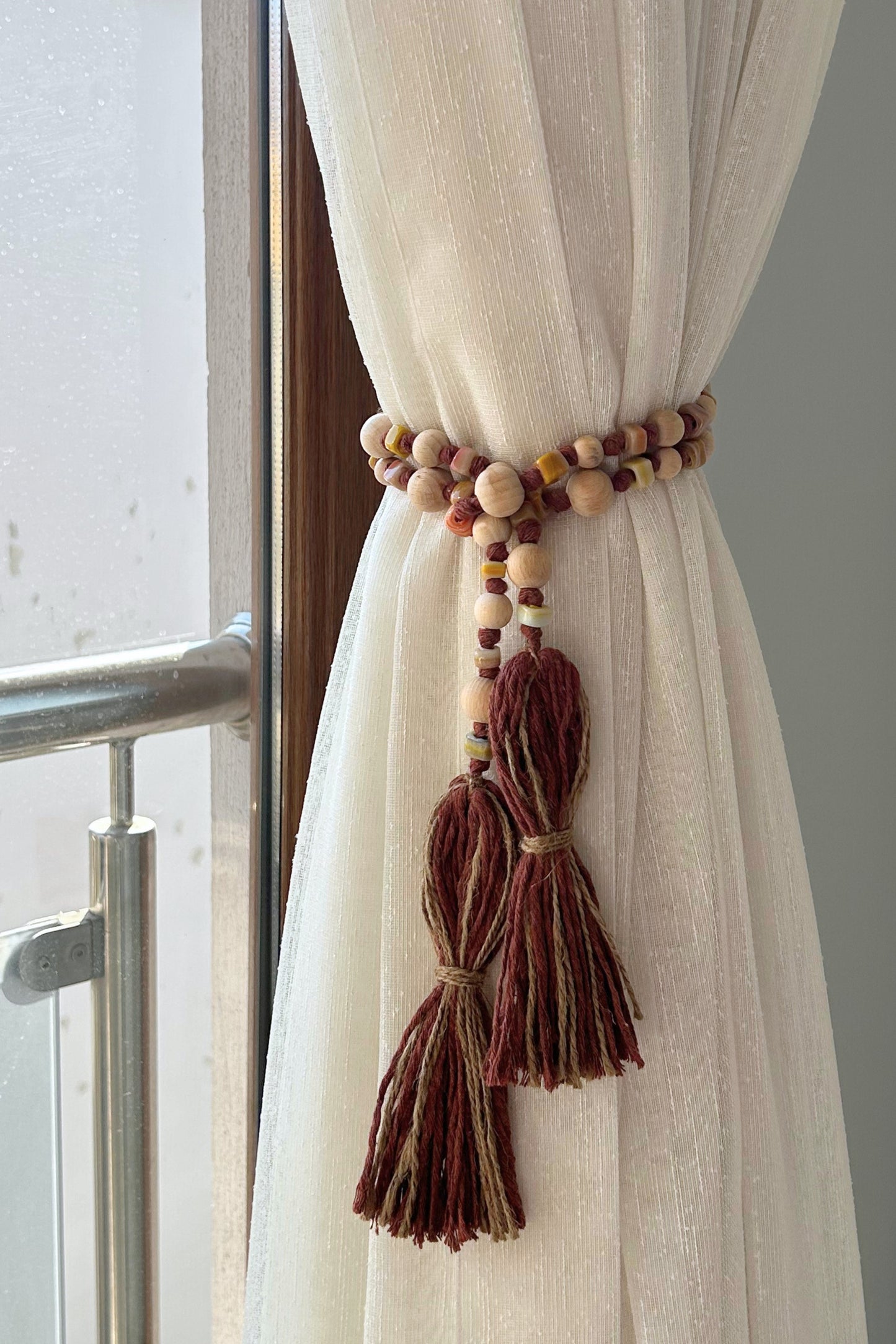 Curtain styled with handmade jute tassel and rustic garland of natural beads