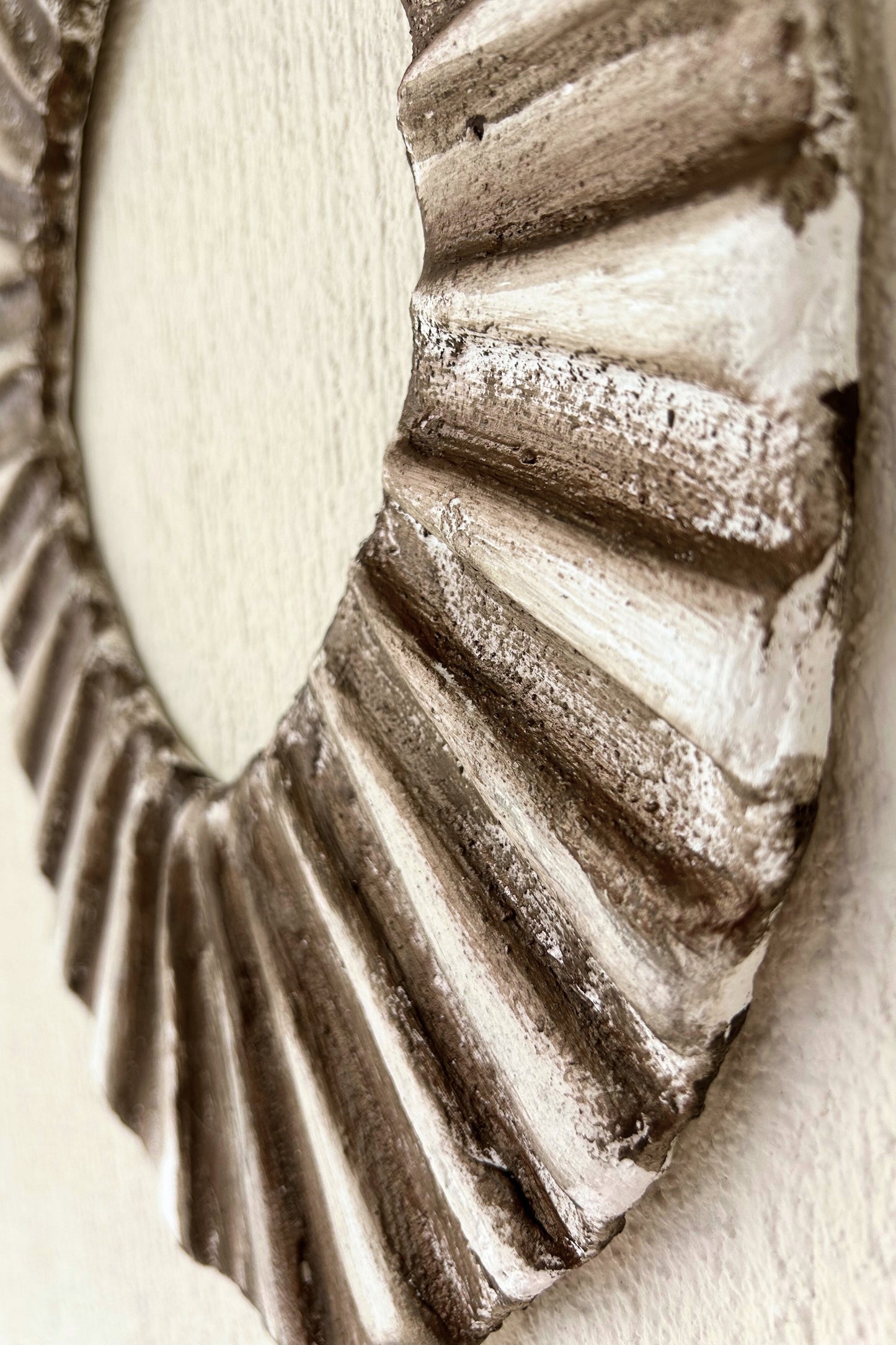 Side profile of oval wall art with natural shadows and handcrafted detail