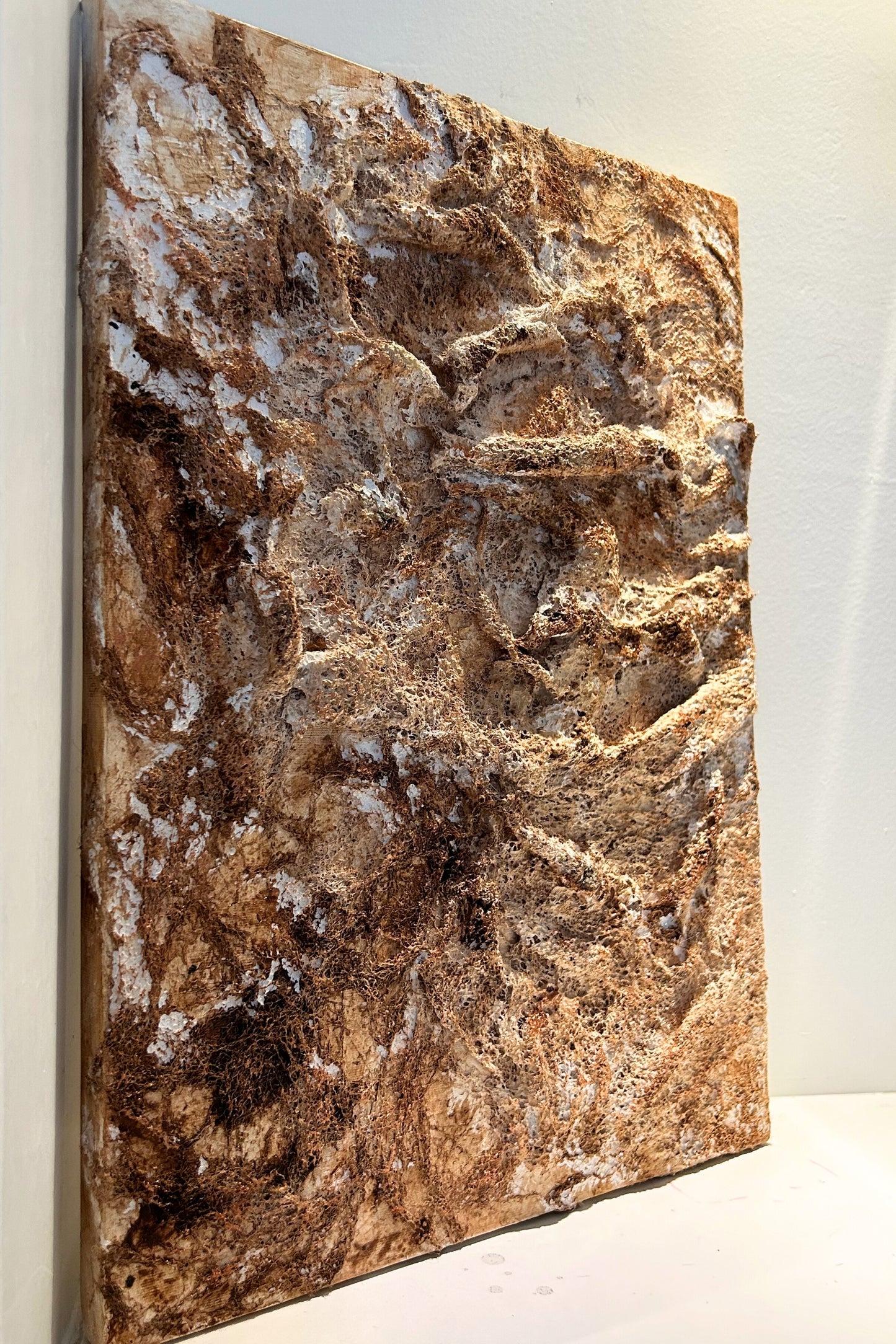 Front view of handcrafted textured wall art in earthy brown tones with copper accents.