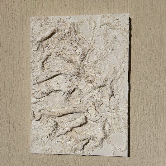 Front view of handcrafted 3D white plaster wall art on canvas, inspired by ocean textures.