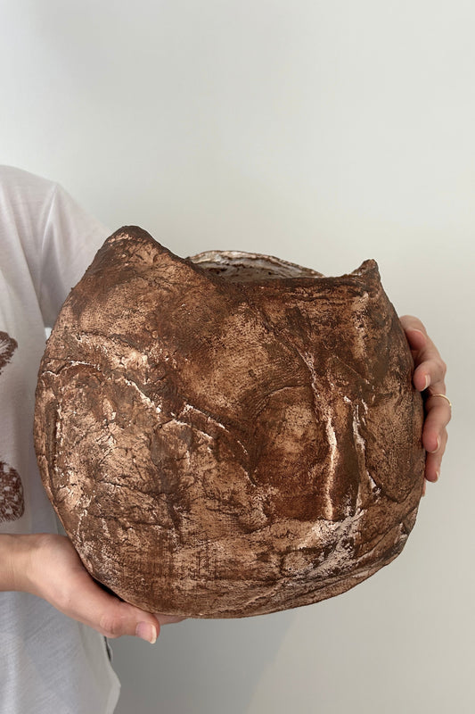 Earthy vase captured in soft natural light, highlighting its unique sculptural details and hand-painted layers.