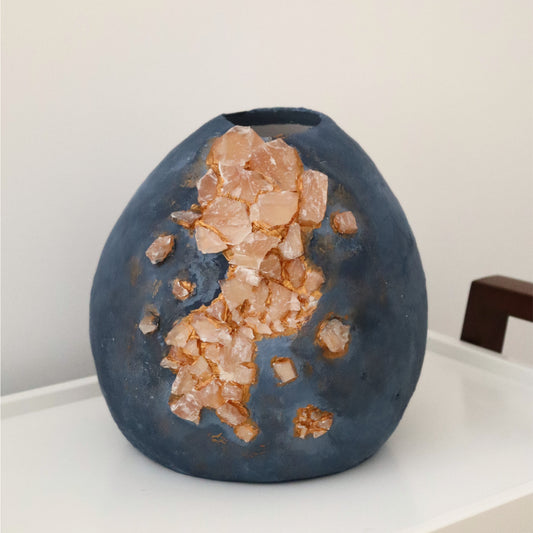 Daylight shot showing texture and stones on handmade blue wabi-sabi vase