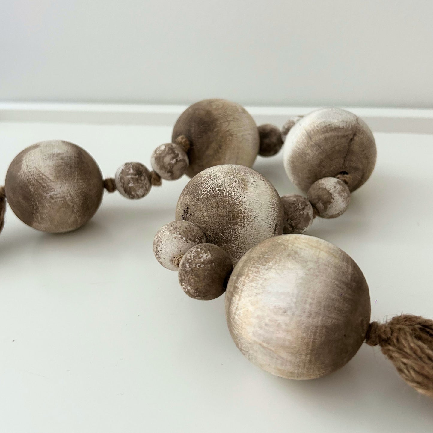 Side angle view of handmade wooden beads on white surface