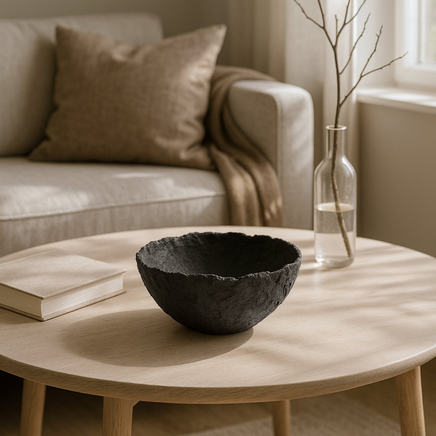 Handmade black wabi sabi bowl on a light wooden coffee table, styled in a minimal Japandi living room with soft natural light and earthy decor.