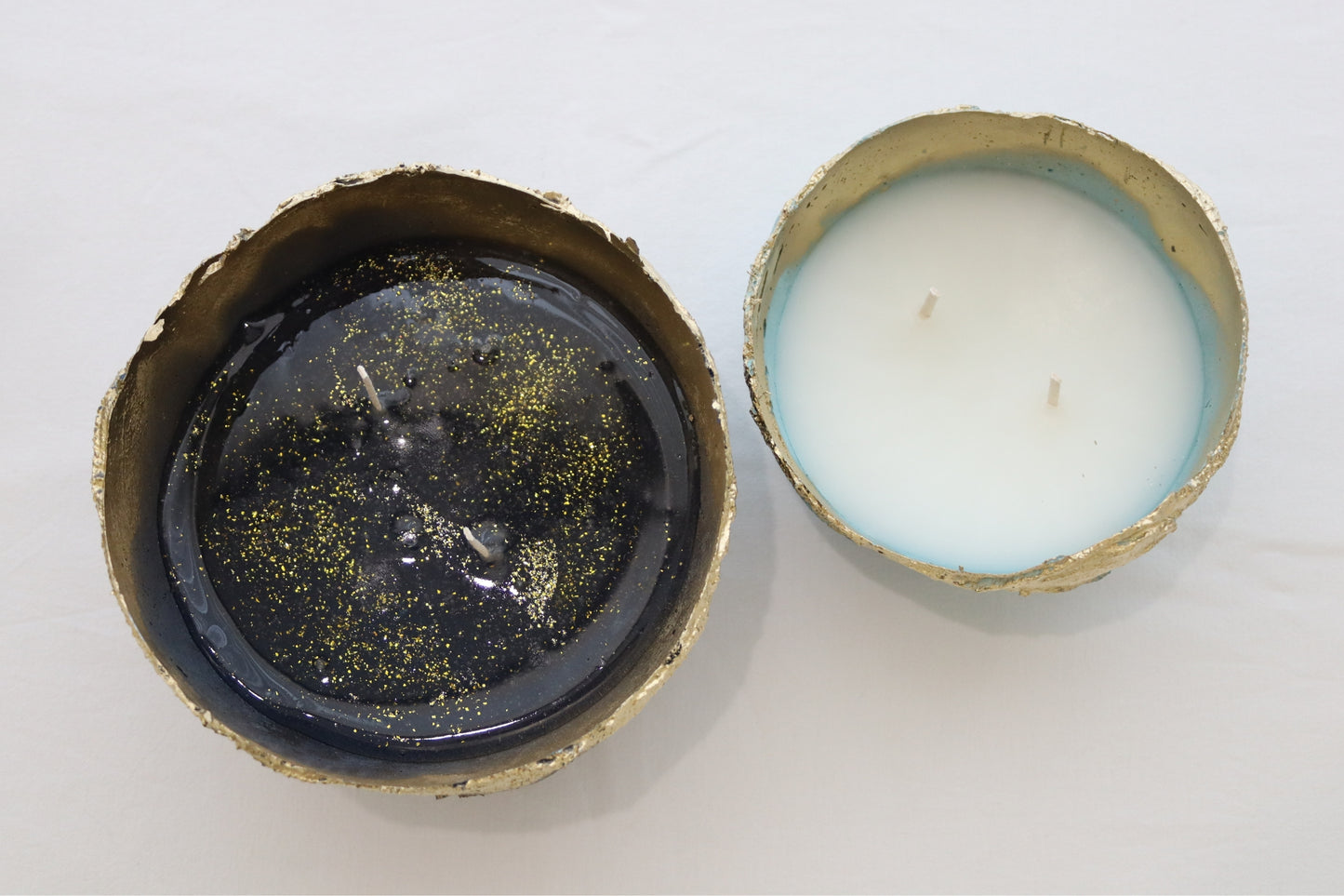 Top view of two handmade candle bowls in blue and navy with contrasting wax tones.