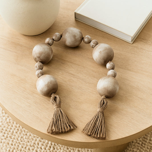 Rustic wooden bead garland with jute tassels styled on a wooden table with book and vase – perfect for boho or coastal home decor