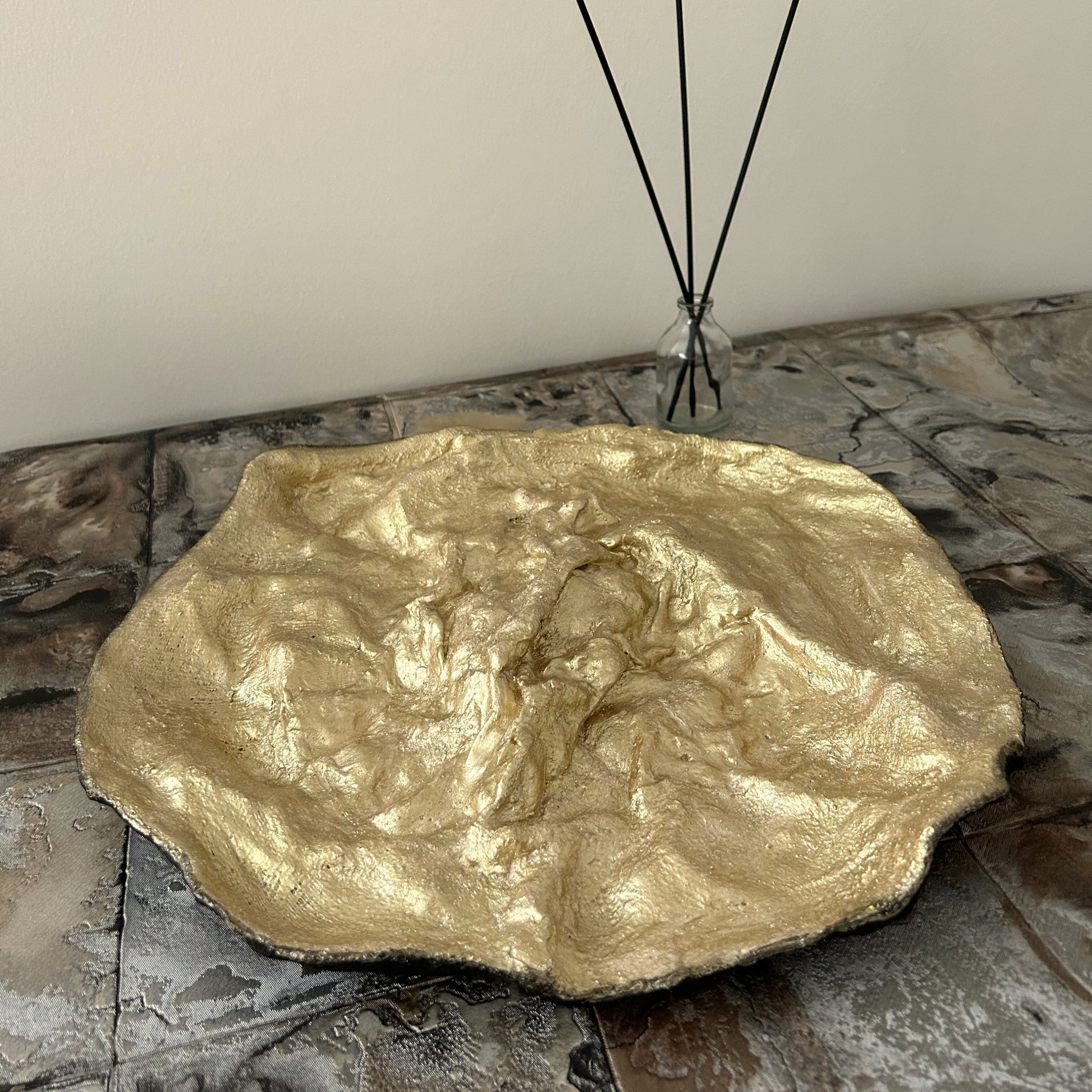 Modern rustic tray with black outer texture and radiant gold interior