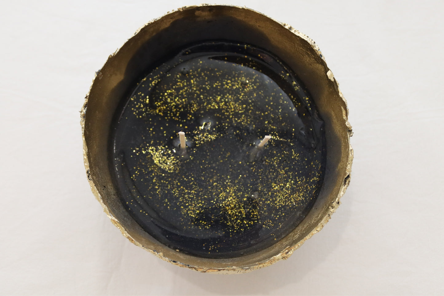 Full top-down image of navy candle bowl with visible sparkles in jelly wax.