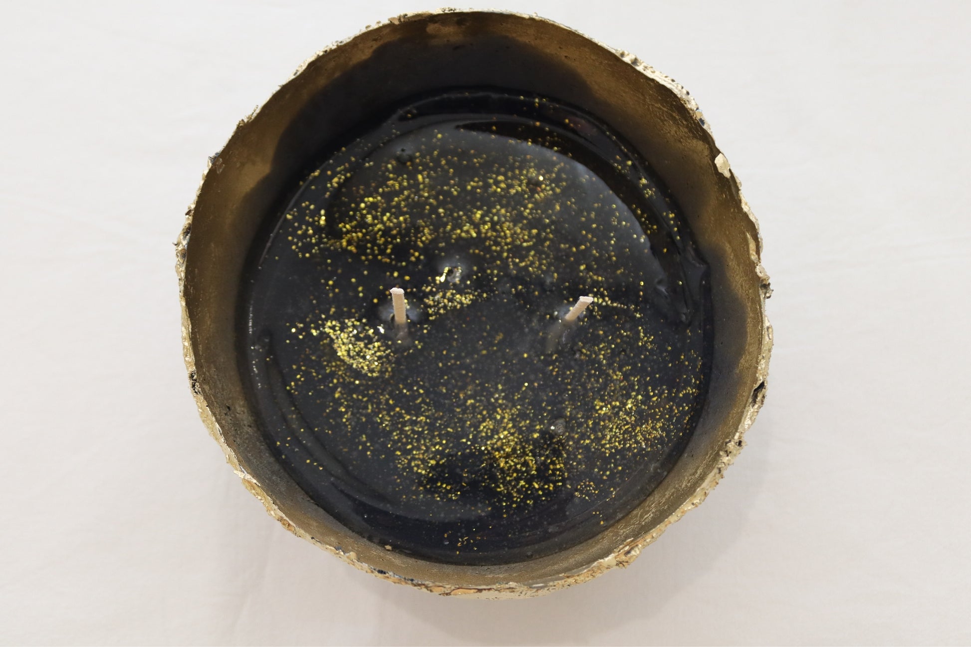 Full top-down image of navy candle bowl with visible sparkles in jelly wax.