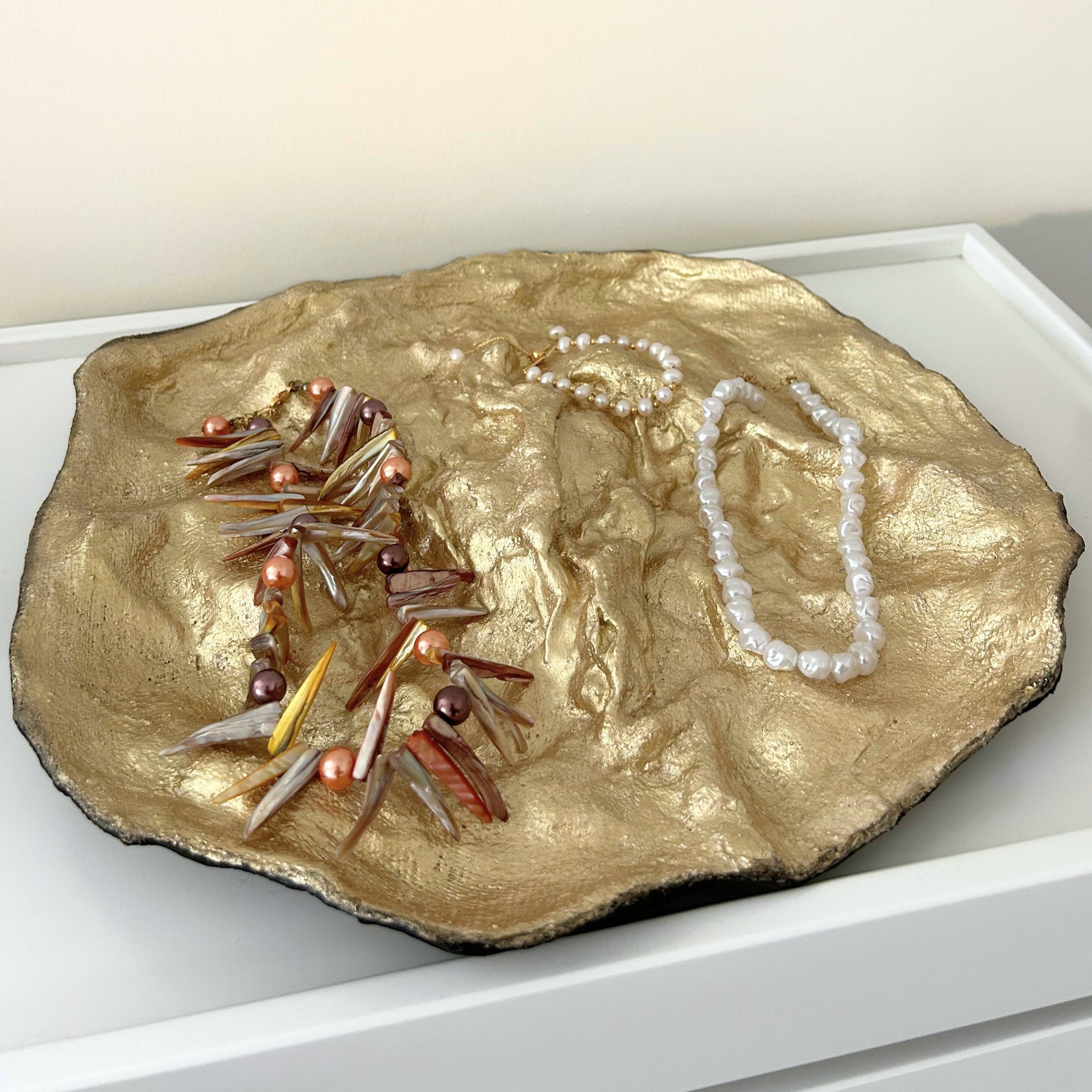 Handmade gold paper mache tray displayed with jewelry for summer styling