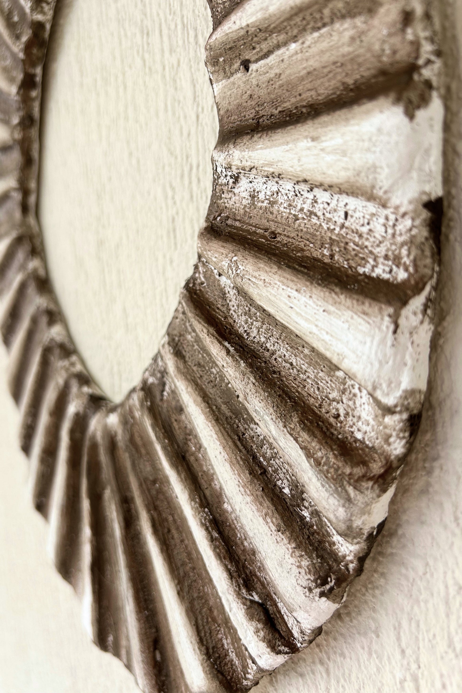 Side profile of oval wall art with natural shadows and handcrafted detail