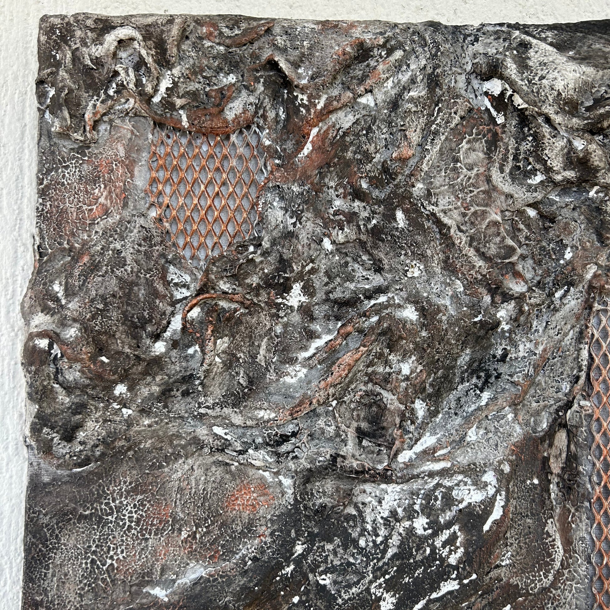 Top left detail of textured plaster with earthy tones and metallic highlights.