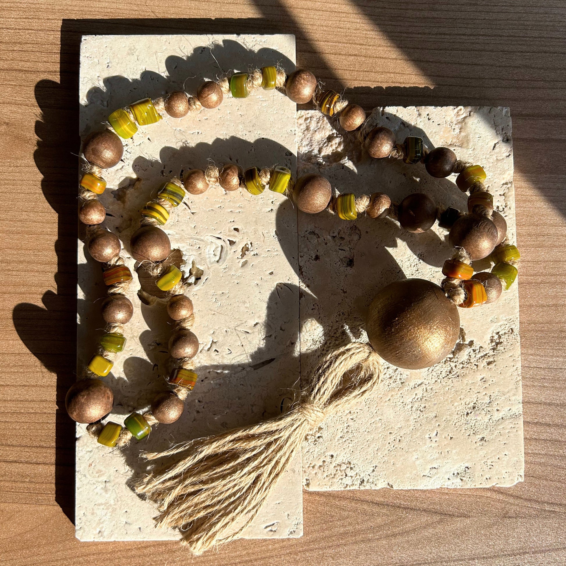 Handcrafted rustic wood and glass bead garland styled on a coffee table with natural lighting.