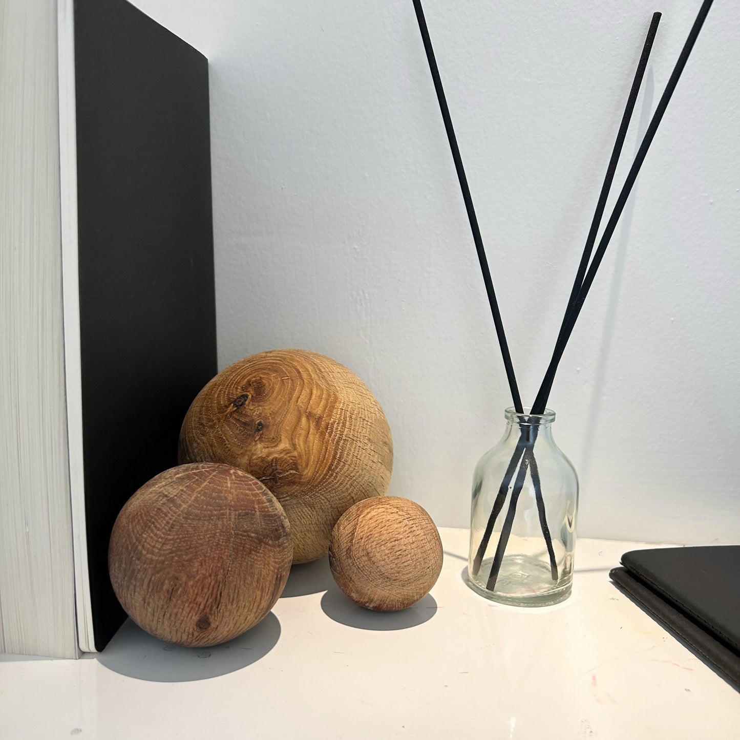 Trio of wooden spheres placed on a black marble surface for organic coffee table styling.