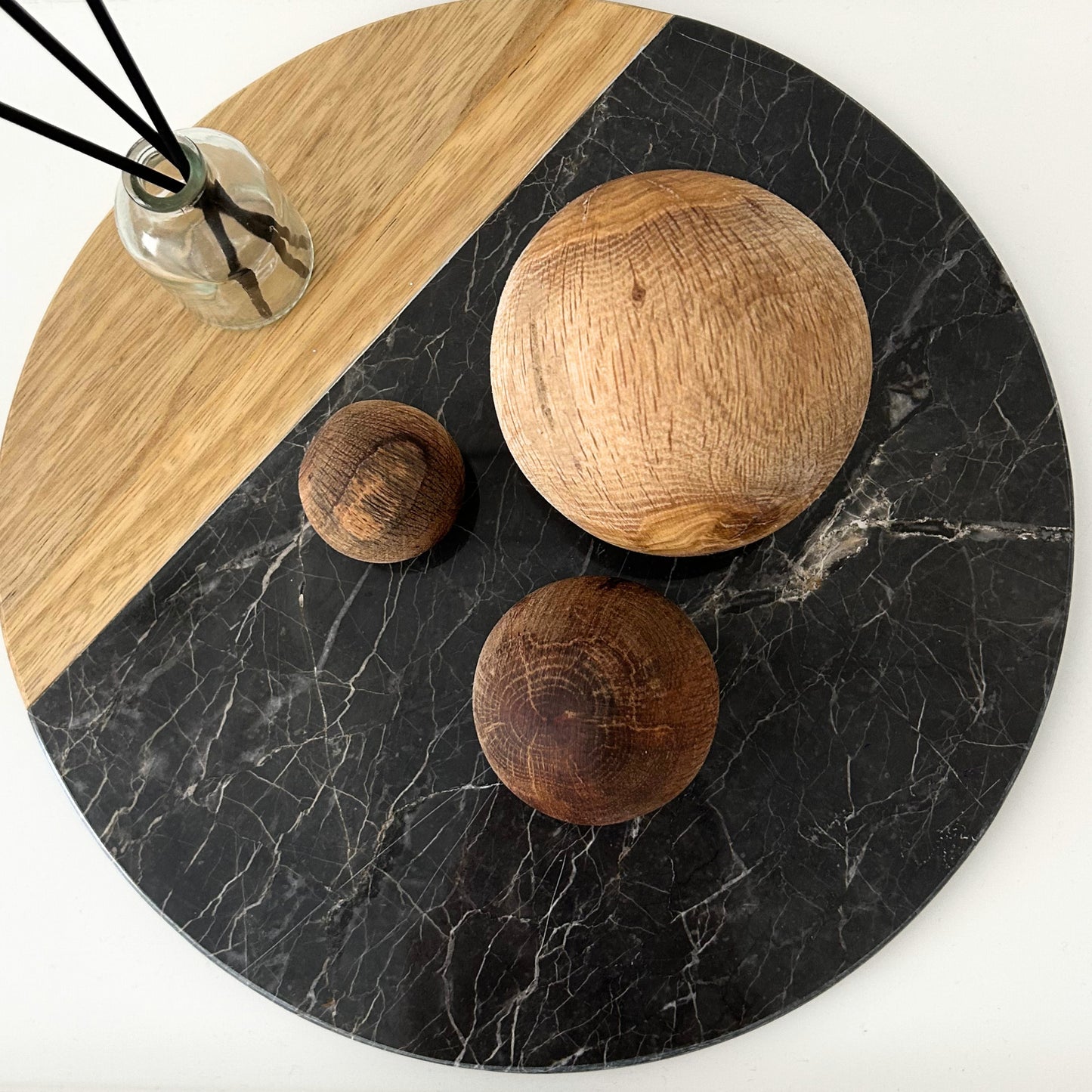 Handcarved wood decor balls styled on a round tray with a natural color palette.