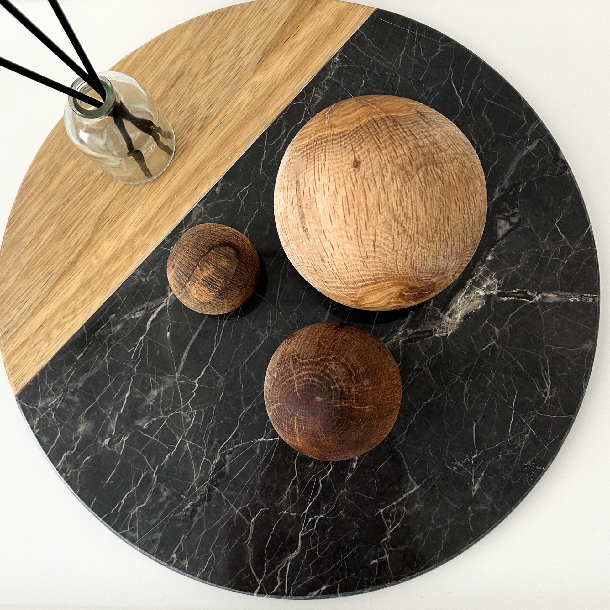 Handcarved wood decor balls styled on a round tray with a natural color palette.
