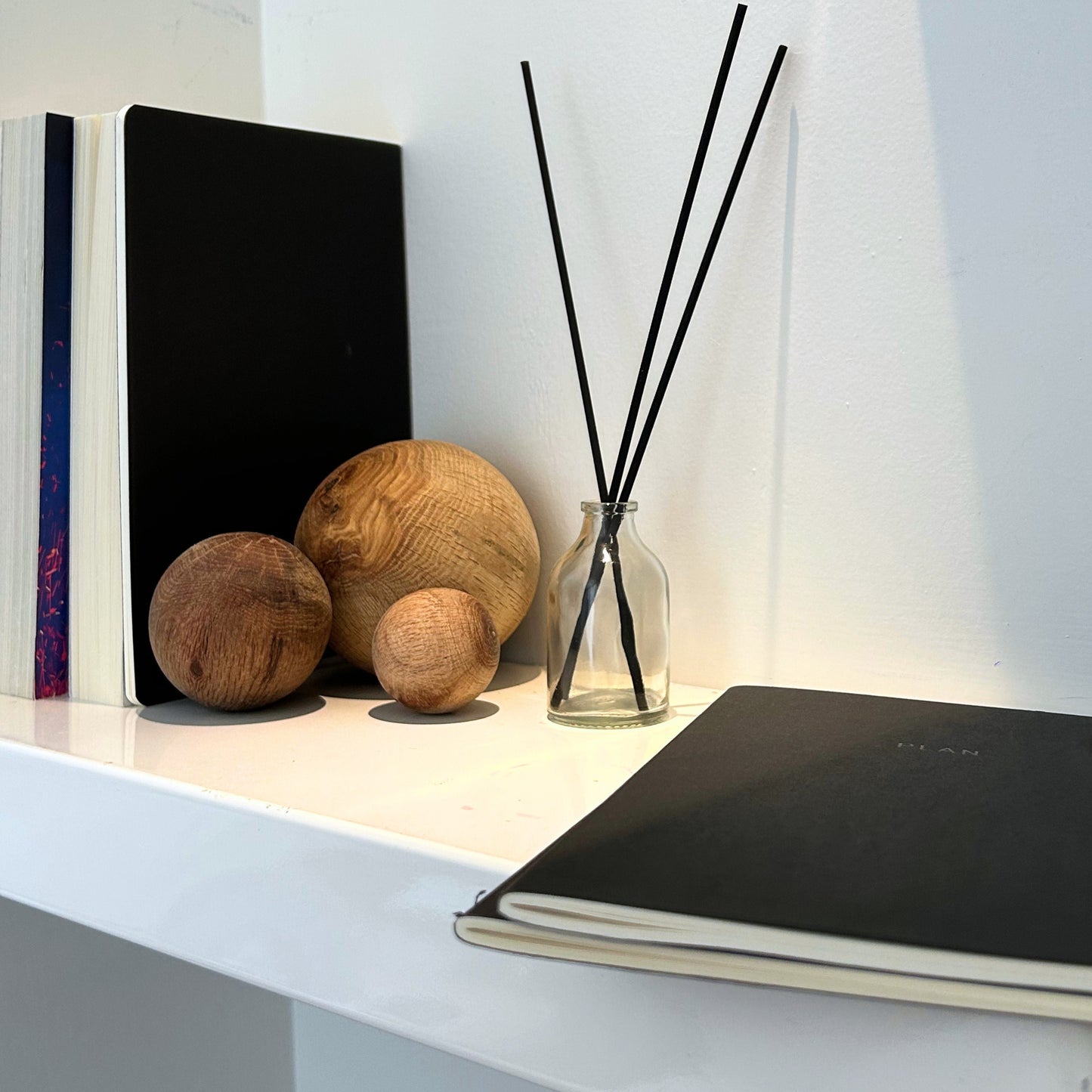 Boho office or shelf decor with handmade wood spheres and matte black backdrop.